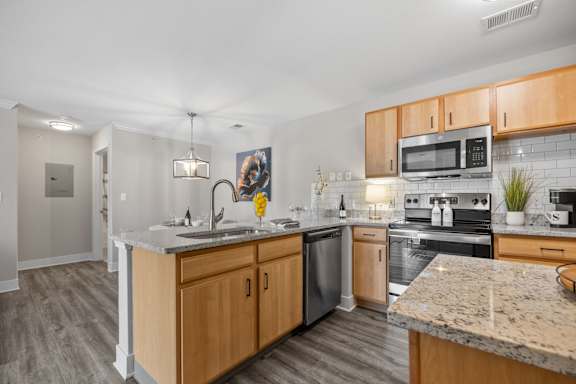 A kitchen with wooden cabinets and granite countertops.