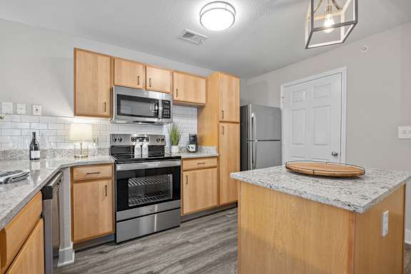 A kitchen with wooden cabinets and a granite countertop.