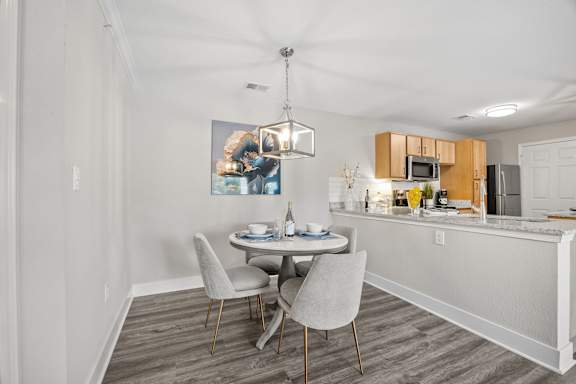 A kitchen with a dining table and chairs.