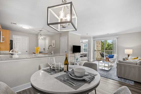 A modern dining room with a round table set for two.