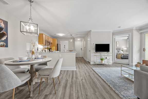 A modern dining room with a table set for two and a television in the background.