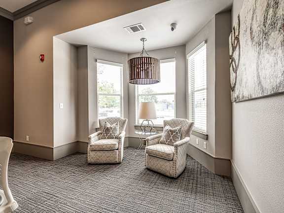 Two chairs are placed in a room with a hanging light fixture.