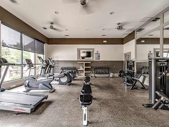 A spacious gym with treadmills, elliptical machines, and weightlifting equipment.