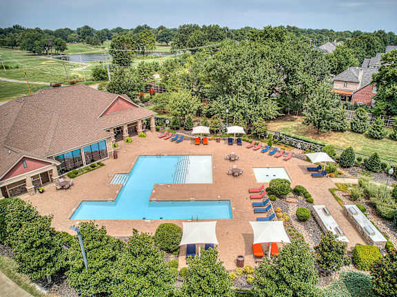 A large outdoor swimming pool surrounded by a patio area with a gazebo.