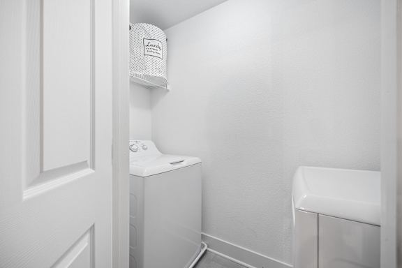 A small white bathroom with a toilet and a washing machine.