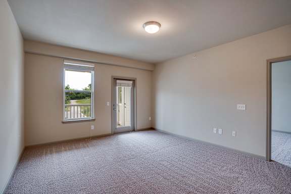Spacious Room with Plush Carpet and Glass Patio Door