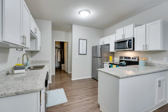 Renovated Kitchen Featuring White Cabinetry & Stainless Steel Appliances