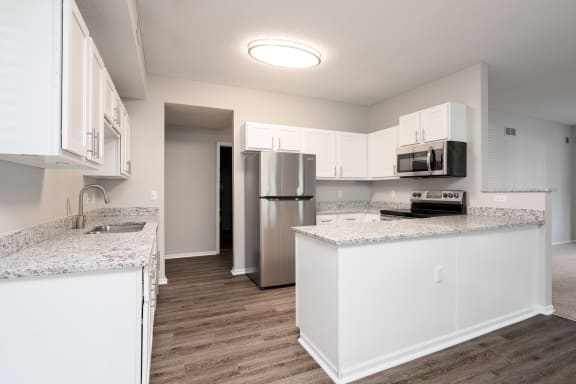 Spacious Kitchen With White Cabinetry & Stainless Steel Appliances