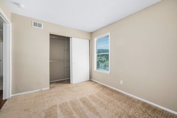 Carpeted Bedroom With Sliding Closet Door & Built-In Shelves