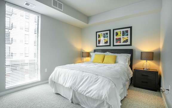 a bedroom with a bed and a large window