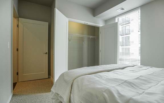 a bedroom with a bed and a closet and a window