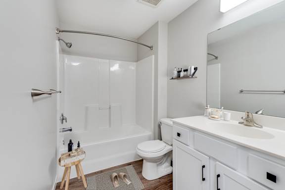 A white bathroom with a toilet, sink, and shower/bathtub.