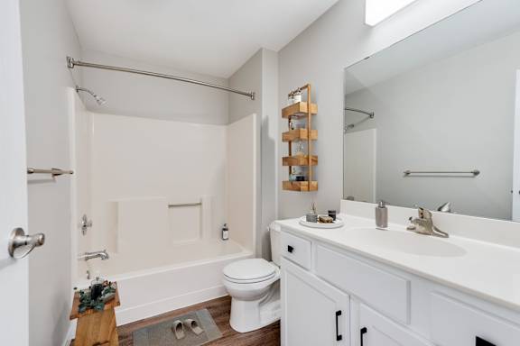 A large, white bathroom with a toilet, sink, and shower/bathtub.