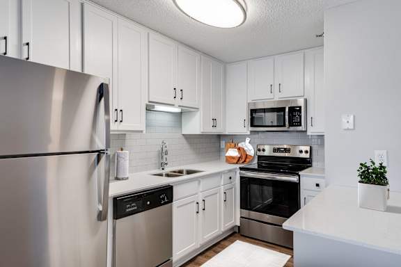 A kitchen with white cabinets and stainless steel appliances.