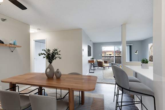A dining room with a wooden table and chairs.