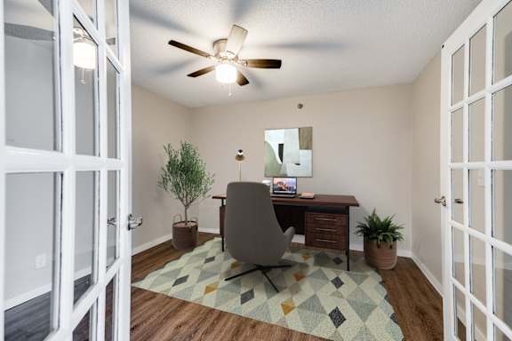 A closed off extra room with a ceiling fan