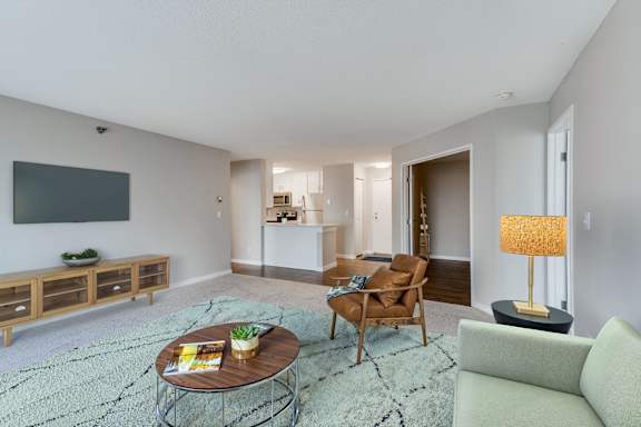 A living room with a grey couch, a coffee table, and a lamp.