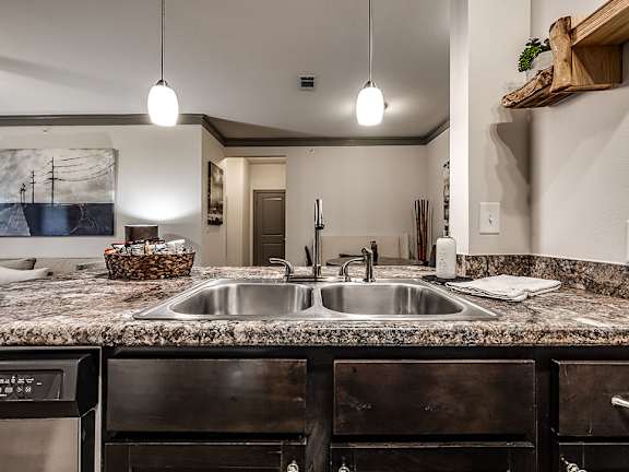 A kitchen with a granite countertop and a sink.