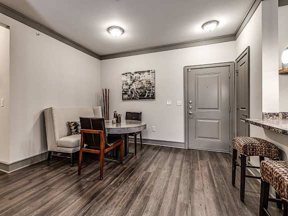 A room with a wooden floor and a grey door.