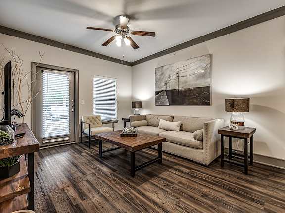 A living room with a couch, a chair, a coffee table, and a painting on the wall.