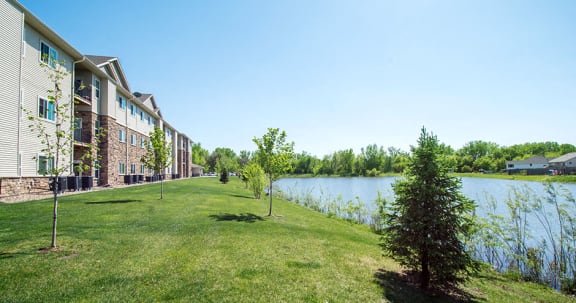 Apartment Homes Overlooking the Pond and Lush Grass
