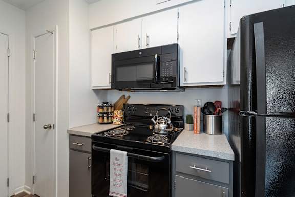 A kitchen with a black oven and a black fridge.