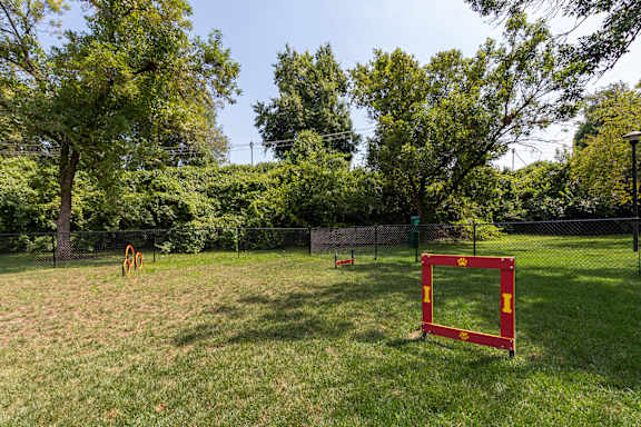 A red square frame stands in a grassy field with trees in the background.