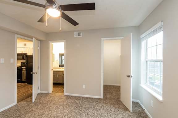 A room with a ceiling fan and a window.