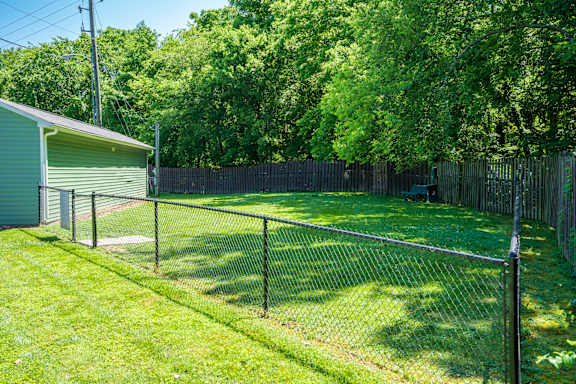 A backyard with a fence and a shed.