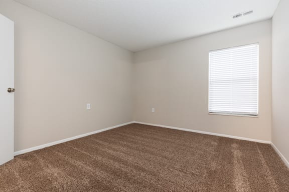 Carpeted Bedroom with Large Window and White Trim