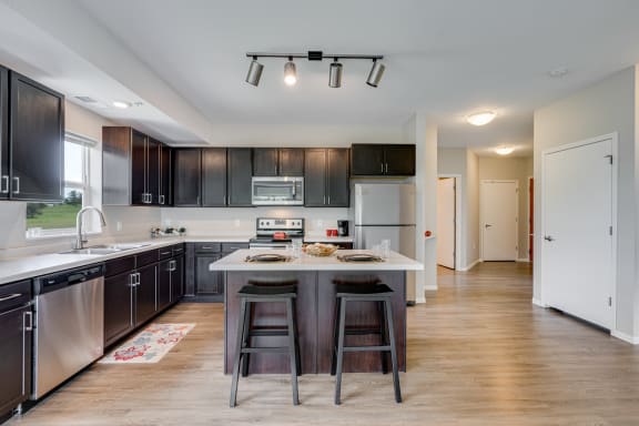 Large Kitchen Featuring Spacious Island With Barstool Seating
