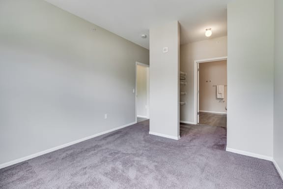 Carpeted Bedroom Featuring Walk-In Closet & Attached Bathroom