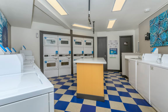 a laundry room with white machines and a yellow counter