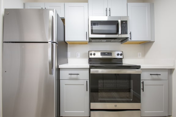 a kitchen with white cabinets and stainless steel appliances