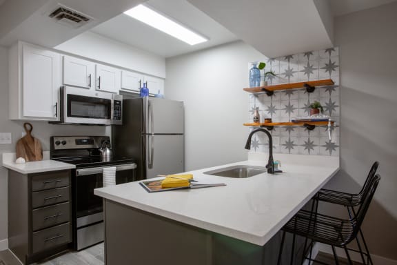 a kitchen with a white counter top and stainless steel appliances