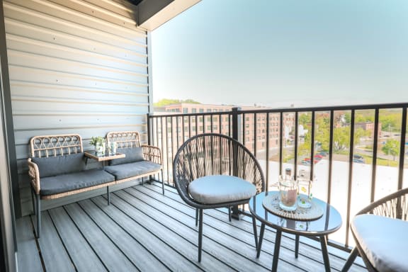 a patio with two chairs and a table on a balcony