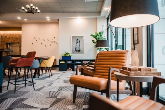 the lobby of a hotel with chairs and tables
