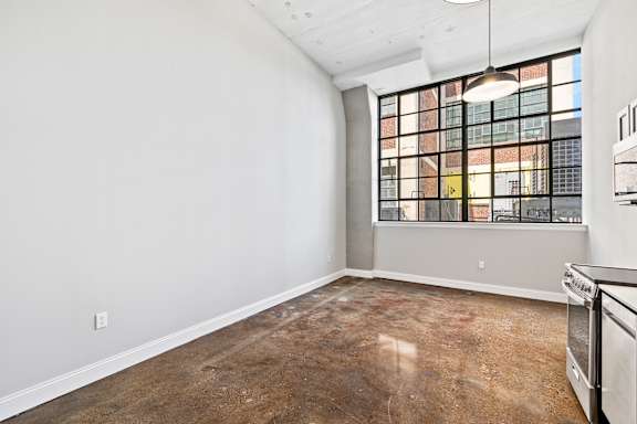 A room with a window and a wall socket.