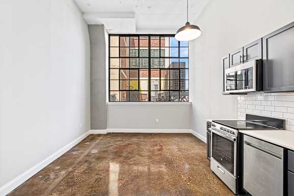A kitchen with a window overlooking a cityscape.