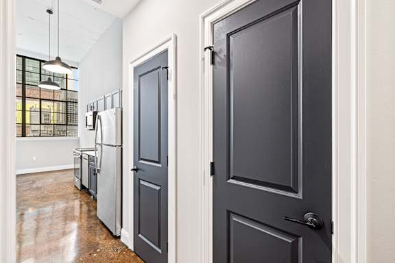 A kitchen with a refrigerator and a door.
