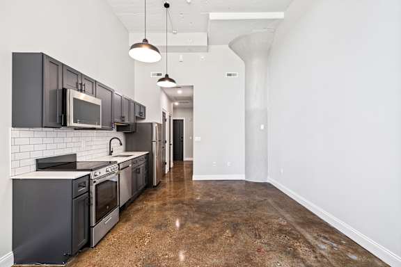 A kitchen with black cabinets and stainless steel appliances.