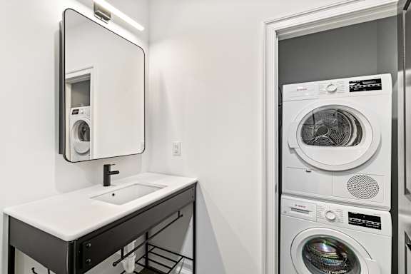A white sink is under a mirror in a small bathroom.