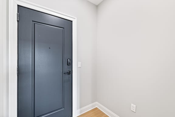 A dark grey door with a black handle and a silver lock.