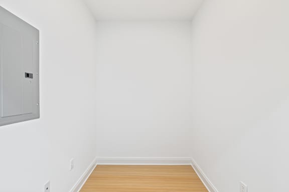 A white room with a wooden floor and a white cupboard.