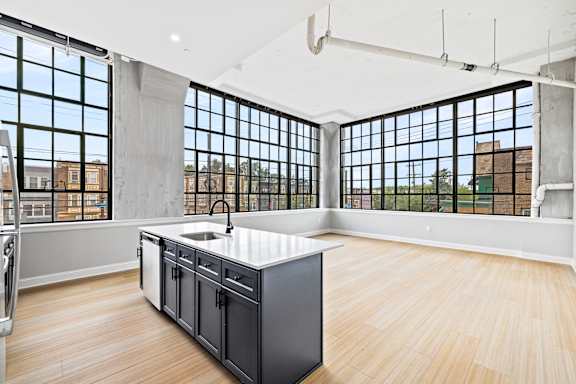 A kitchen with a large island and wooden floors.