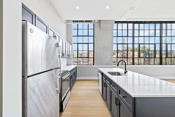 A modern kitchen with stainless steel appliances and a large window.
