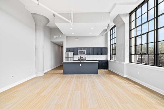 A kitchen with a wooden floor and a large island in the middle.