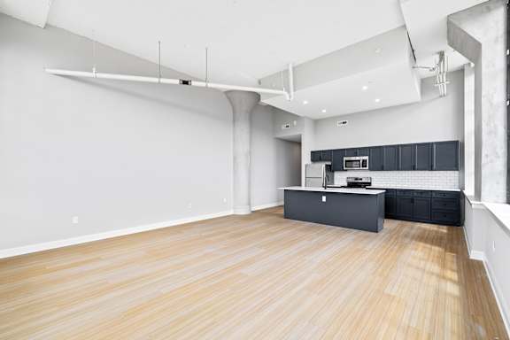 A kitchen with a wooden floor and white walls.