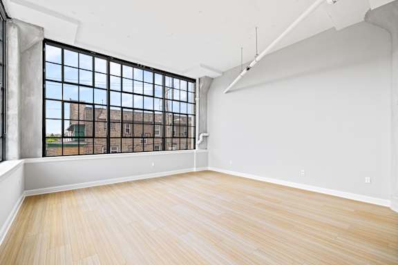 A room with a large window and wooden flooring.