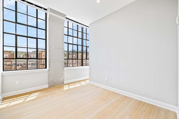 A large empty room with a view of the city through the windows.